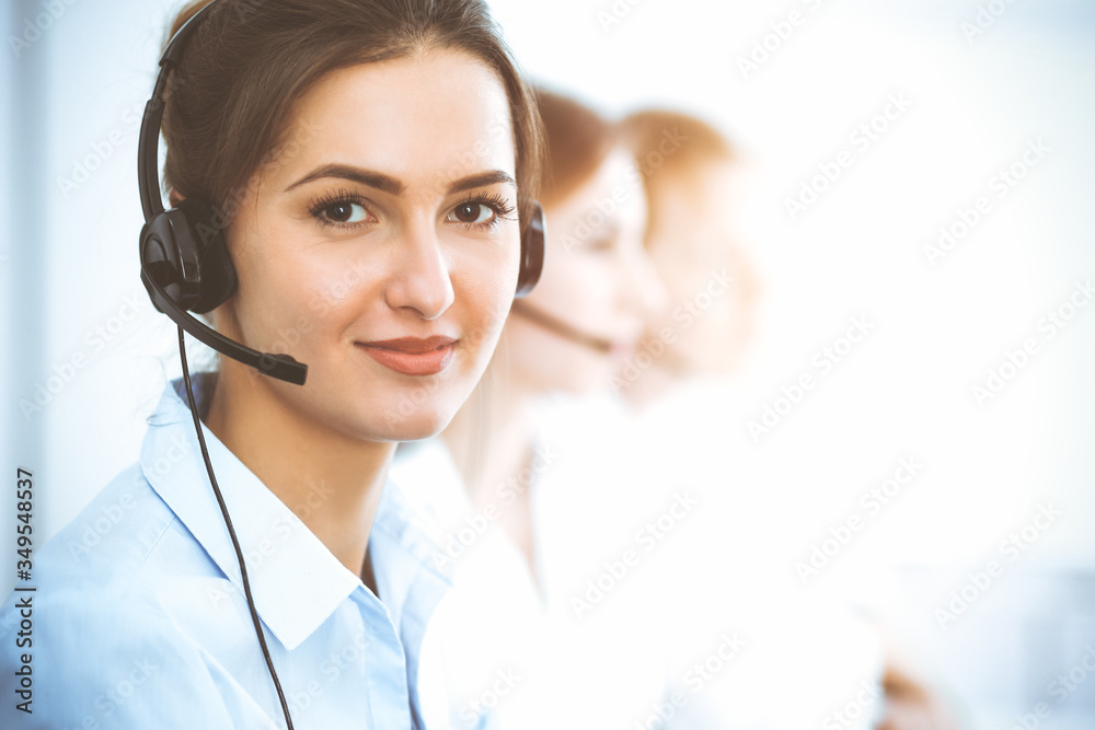 Call center operators. Focus on beautiful business woman using headset Call center operators. Focus on beautiful business woman using headset