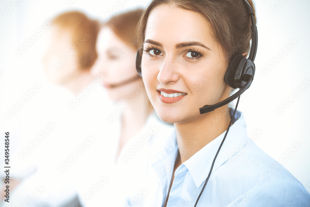 Call center operators. Focus on beautiful business woman using headset Call center operators. Focus on beautiful business woman using headset