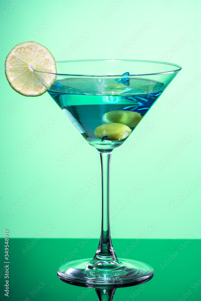 cocktail with martini, olives and lime wedge