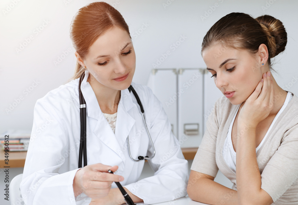 Doctor and patient sitting and discussing health examination results in sunny clinic Doctor and patient sitting and discussing health examination results in sunny clinic
