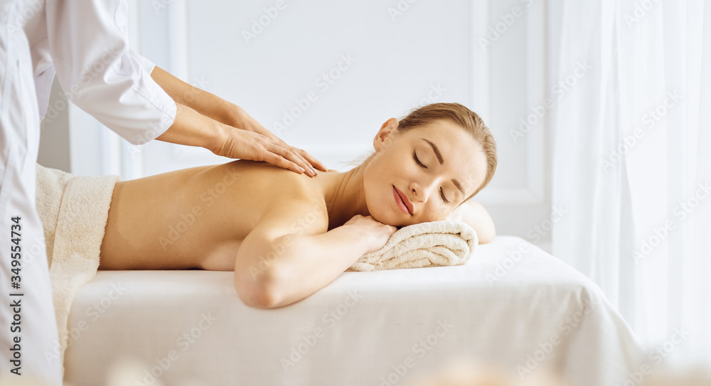 Beautiful woman enjoying back massage with closed eyes. Spa treatment concept Beautiful woman enjoying back massage with closed eyes. Spa treatment concept