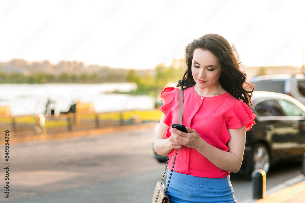 A girl walks down the street and looks at the phone A girl walks down the street and looks at the phone