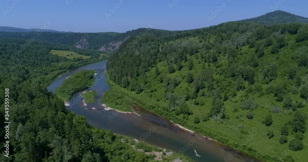 AERIAL VIEW: People in the Long tail boat. Drone view of a boat floating through the blue clear waters of a mountain river in the Siberian taiga. Summer Day AERIAL VIEW: People in the Long tail boat. Drone view of a boat floating through the blue clear waters of a mountain river in the Siberian taiga. Summer Day