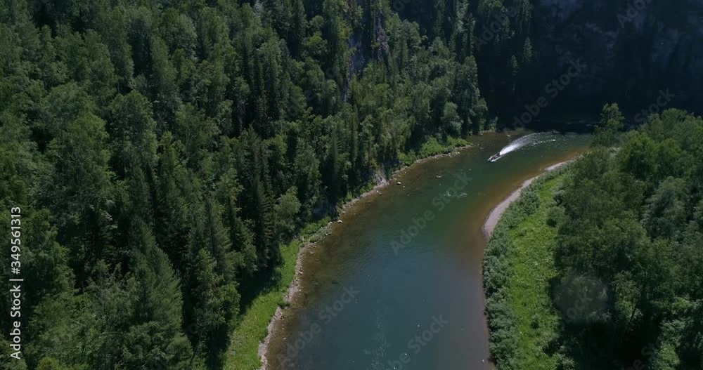 AERIAL VIEW: People in the Long tail boat. Drone view of a boat floating through the blue clear waters of a mountain river in the Siberian taiga. Summer Day AERIAL VIEW: People in the Long tail boat. Drone view of a boat floating through the blue clear waters of a mountain river in the Siberian taiga. Summer Day