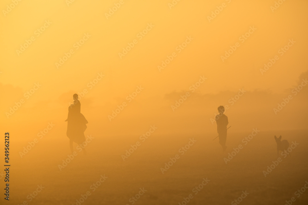 silhouette of family walking to work during foggy sunrise