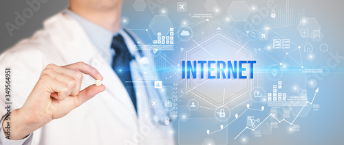 Doctor giving a pill with INTERNET inscription, new technology solution concept