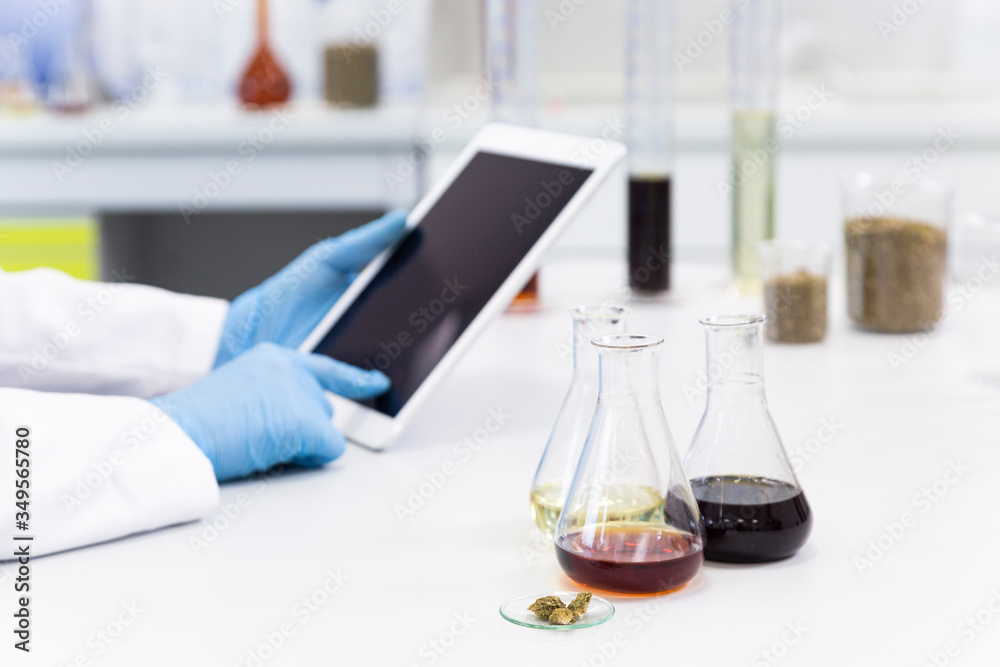 Scientist’s hands working with tablet in cbd laboratory