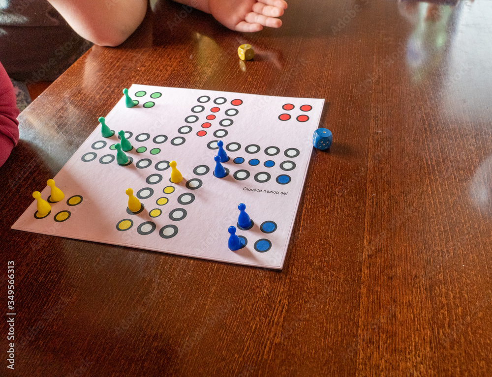 A girl playing a board game and rolls dice. Hand throws the dice on the background of colorful blurred fantasy Board games, gaming moments in dynamics. selected focus A girl playing a board game and rolls dice. Hand throws the dice on the background of colorful blurred fantasy Board games, gaming moments in dynamics. selected focus