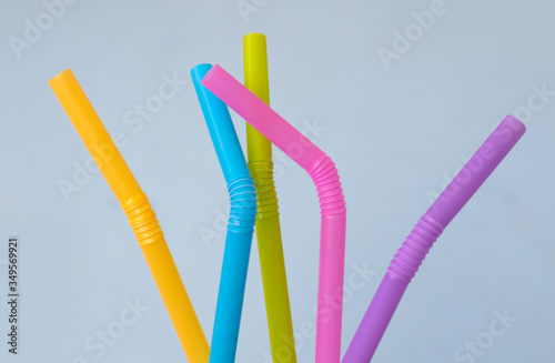Colorful plastic straws on blue background