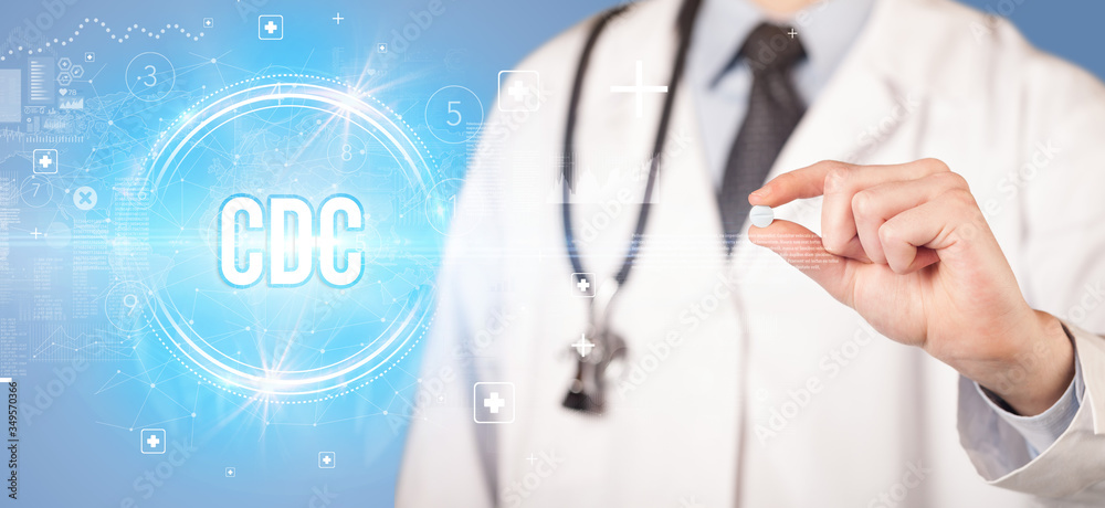 Close-up of a doctor giving you a pill with CDC abbreviation, virology concept Close-up of a doctor giving you a pill with CDC abbreviation, virology concept
