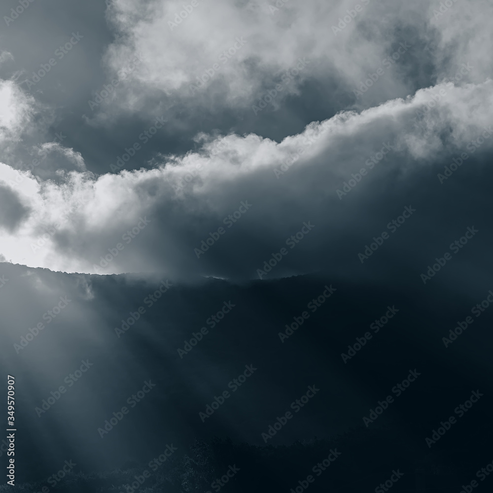 sun's rays in foggy haze and clouds in the mountains.