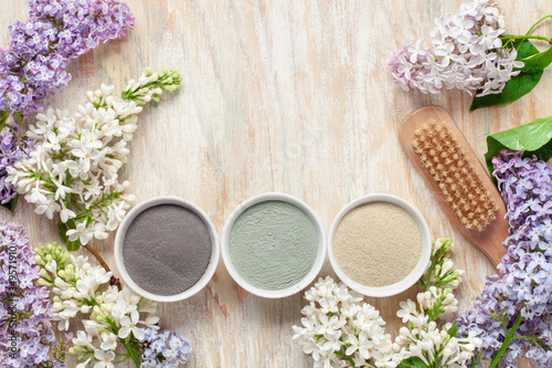 Spa Wellness Background, Natural Cosmetics, different Clay Powder, Preparing Skincare Products. Blossoming lilac branch. Springtime Spa concept. Top View