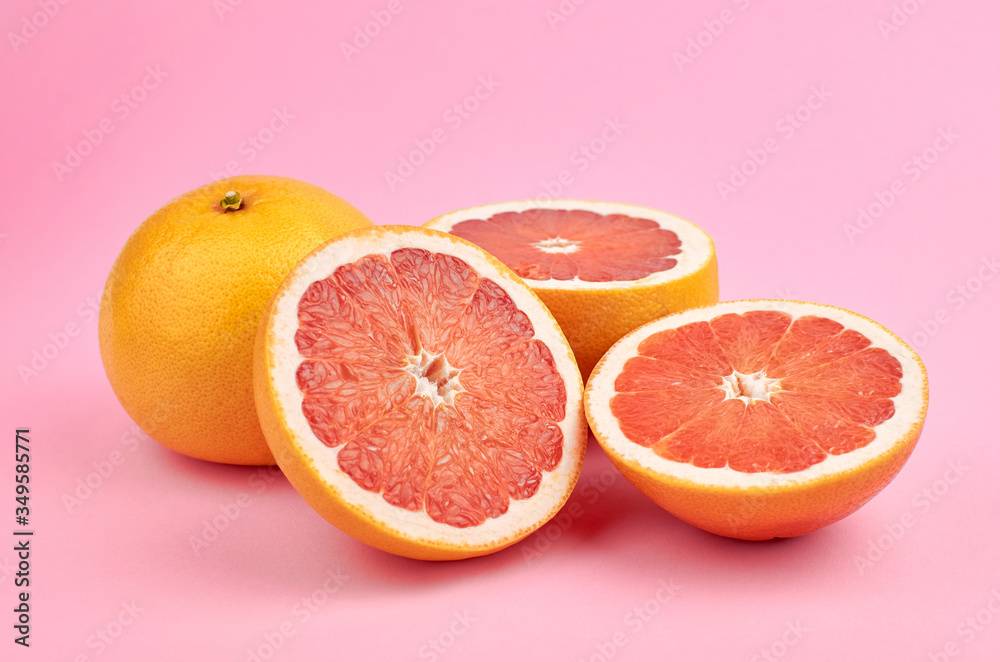 Red grapefruit citrus fruits over pink background Red grapefruit citrus fruits over pink background