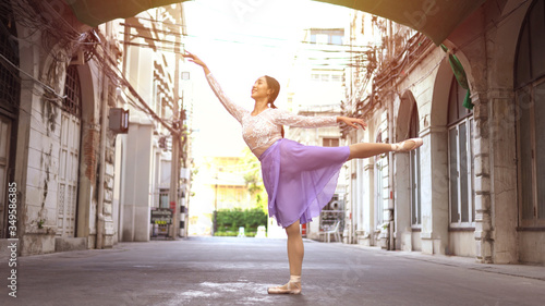 Canvas Print Young beautiful ballerina dancing along the street