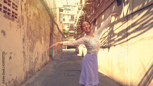 Young beautiful ballerina dancing along the street © witthaya