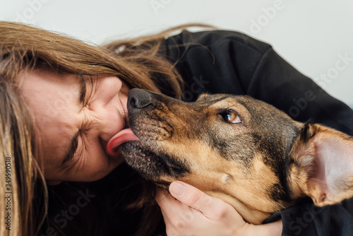 Fotografie Young woman laughing with her dog licking her face