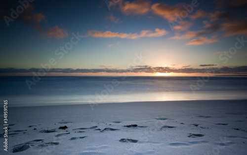 long exposure image of sandy beach and clouds