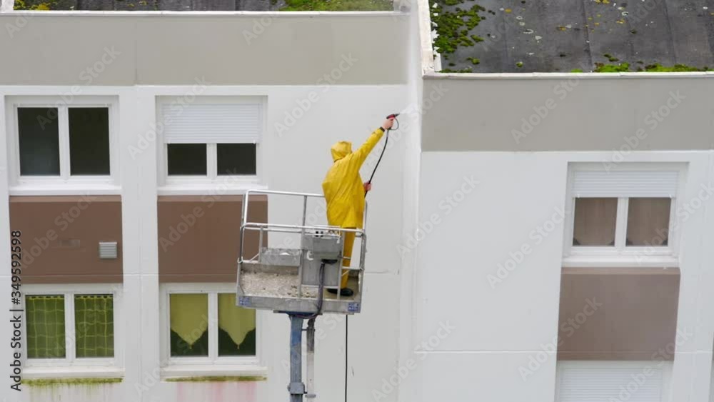 Homme utilisant un nettoyeur haute pression sur une nacelle