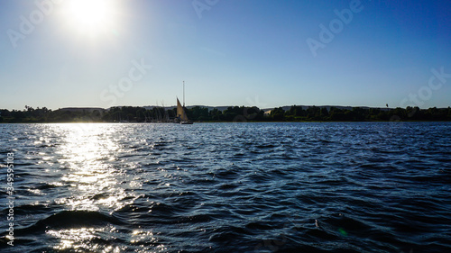 Sunny crusing in Egypt Nile river with fellucca boat yacht bright blue sky
