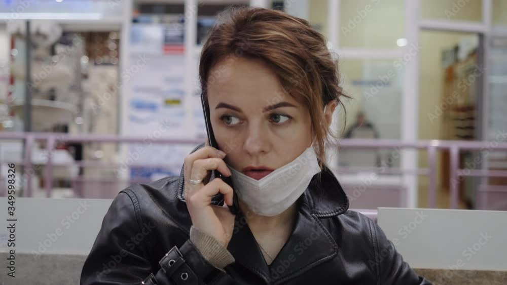 A business woman in a protective mask communicates in a shopping center A business woman in a protective mask communicates in a shopping center