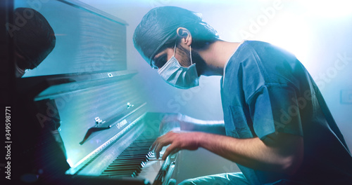 Il medico pianista suona al pianoforte con la mascherina photo