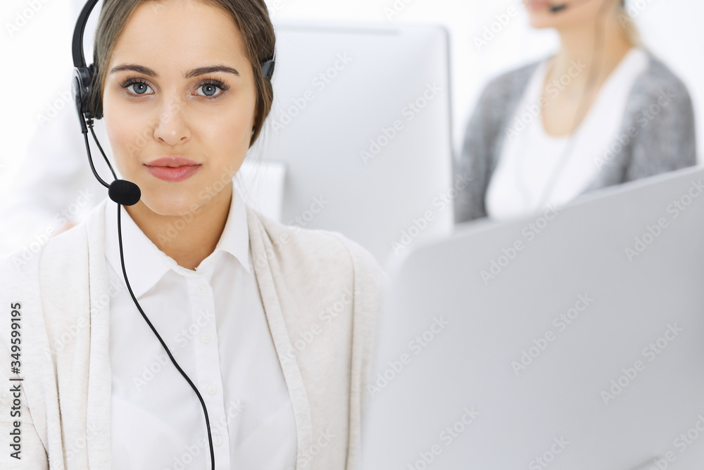 Call center. Group of diverse operators at work. Beautiful woman in headset communicating with customers of telemarketing service. Business concept Call center. Group of diverse operators at work. Beautiful woman in headset communicating with customers of telemarketing service. Business concept