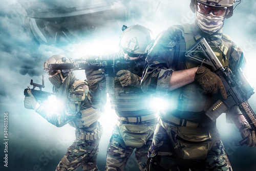 Three US marine corps soldiers with rifle. Uniform conforms to Tactical Units of Police. Shot in studio. Light and smoke on a black background