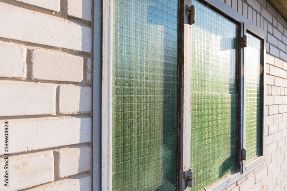 Green window with bars in a white brick building Green window with bars in a white brick building