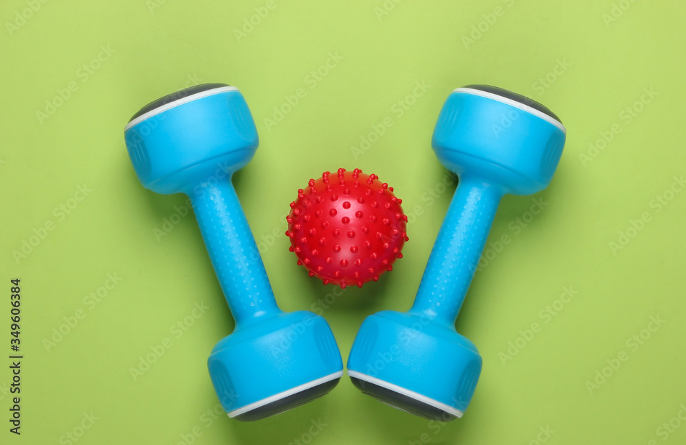 Dumbbell with massage ball on green background. Fitness, healthy lifestyle concept. Studio shot. Top view Dumbbell with massage ball on green background. Fitness, healthy lifestyle concept. Studio shot. Top view