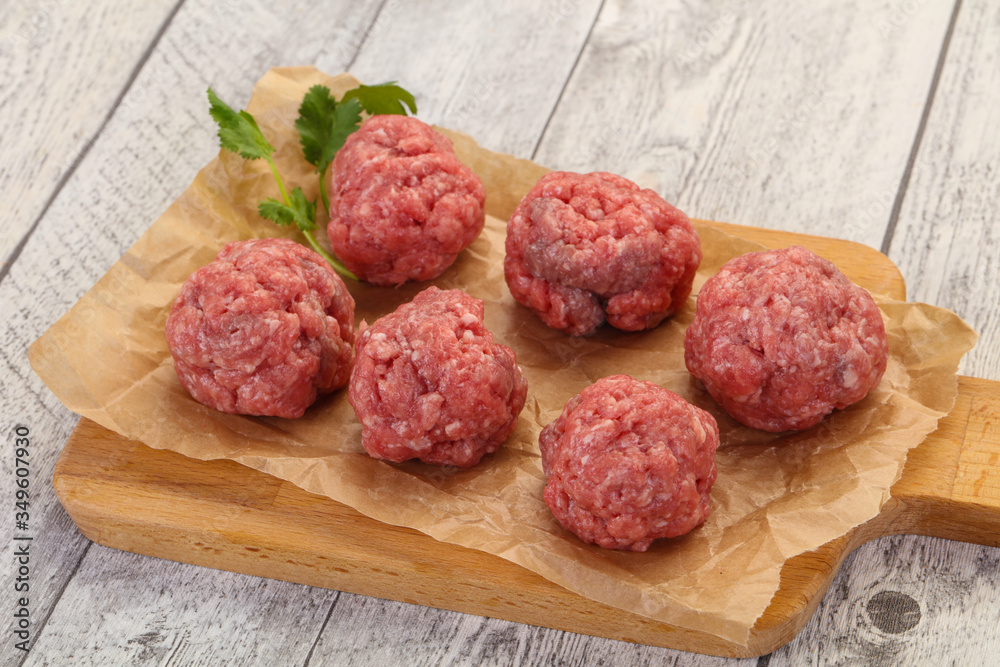 Raw meatball over wooden background Raw meatball over wooden background