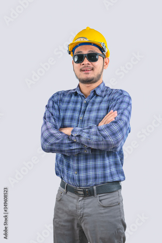 Young engineer asian man wearing long sleeve striped shirts with arms crossed and yellow hard hat © background photo