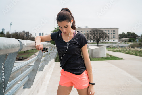 Athletic woman listening to music on a break from training.