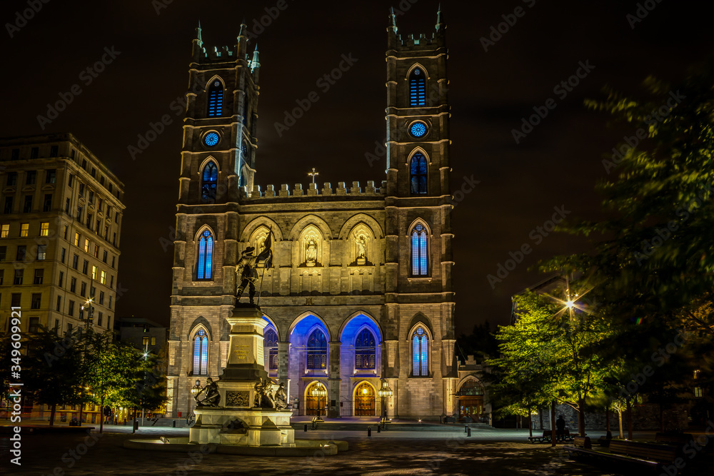 Night view of the Notre-Dame Basilica and Place dArmes square, with visitors, in Montreal, Quebec, Canada