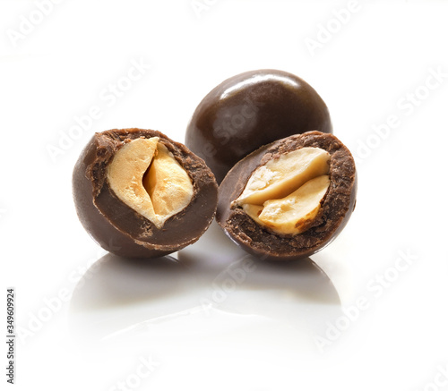 Candy chocolate balls with nuts in them,  on white background whole and halves. Isolated
