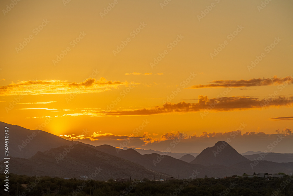 The sun setting behind mountains in the Sonoran Desert of Arizona.