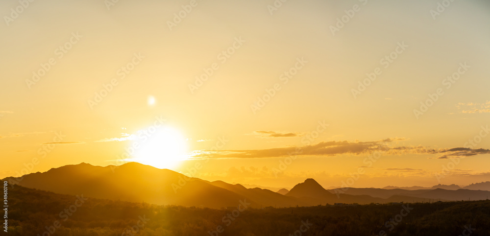 A Panorama of the sun setting behind mountains in the Sonoran Desert of Arizona.