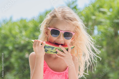 Portrait of a young blonde little girl with watermelon, Summertime fun.