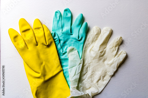 Different types of rubber gloves and a latex glove, three colorful rubber gloves - Image
