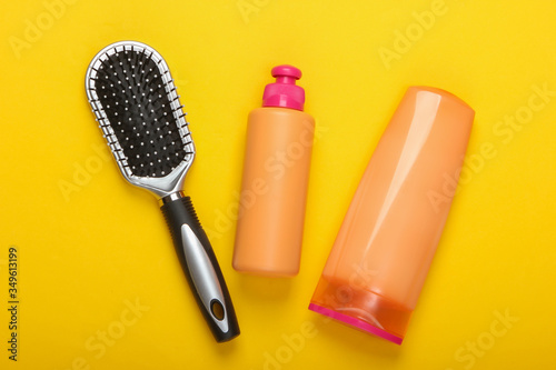 Shampoo bottles, hair conditioner, hair brushes on a pink background. Hair care. Hygiene. Beauty flat lay