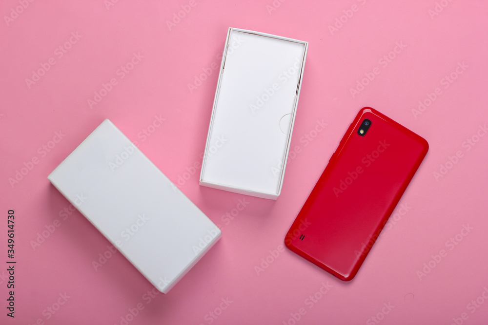 New smartphone with box on a pink background. Buying new gadgets. Top view New smartphone with box on a pink background. Buying new gadgets. Top view