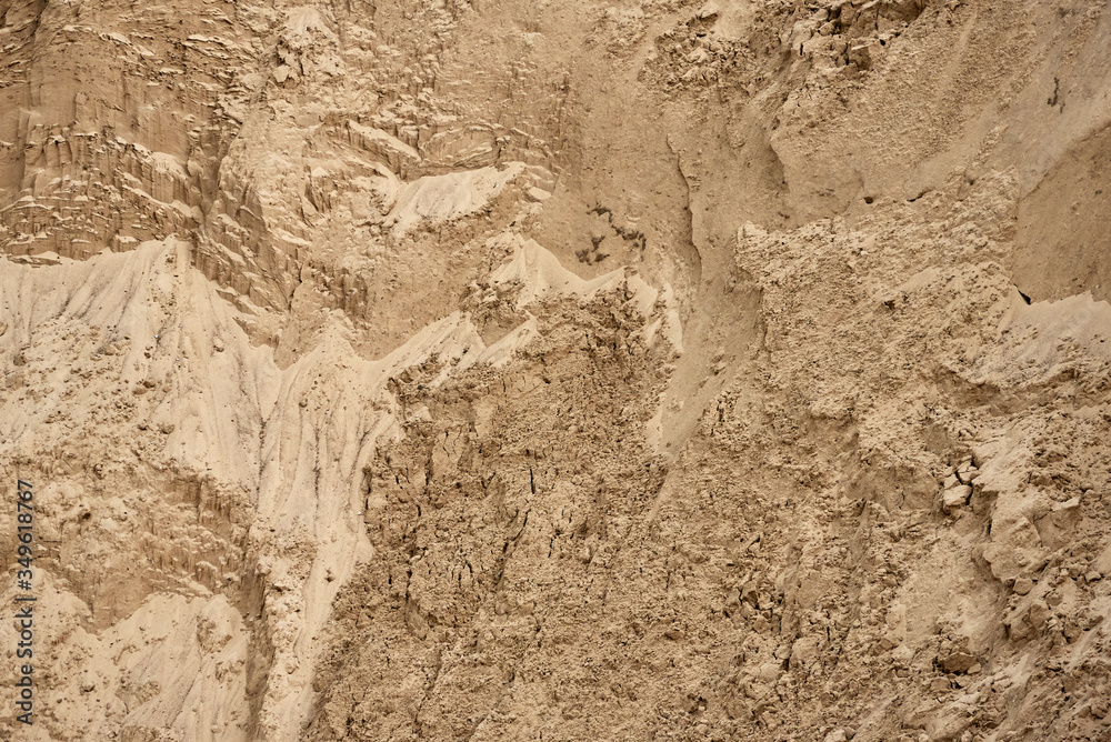 The wall of a deep sand pit with a very interesting complex structure. Background, texture