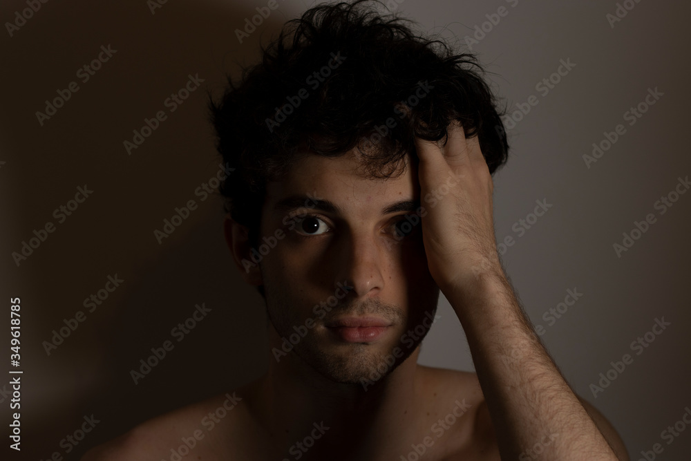 Young man teenager touching head hand curly hear