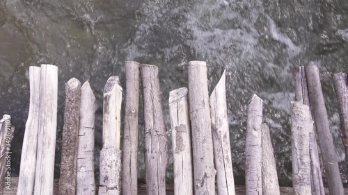 Top down view of bubbly water flowing under a wooden bridge in the river. River surge continuously rushing under a bridge. photo