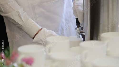 Bartender making breakfast tea at the hotel wearing in white. Close up footage.
