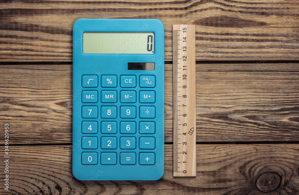Calculator with a ruler on a wooden background. Top view Calculator with a ruler on a wooden background. Top view