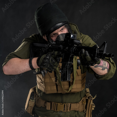 Police officer in gas mask with assault rifle. Uniform conforms to elite task force of the United States. Shot in studio. 