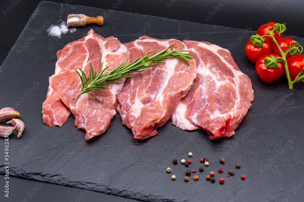 pork raw steak and ingredients on black slate pork raw steak and ingredients on black slate