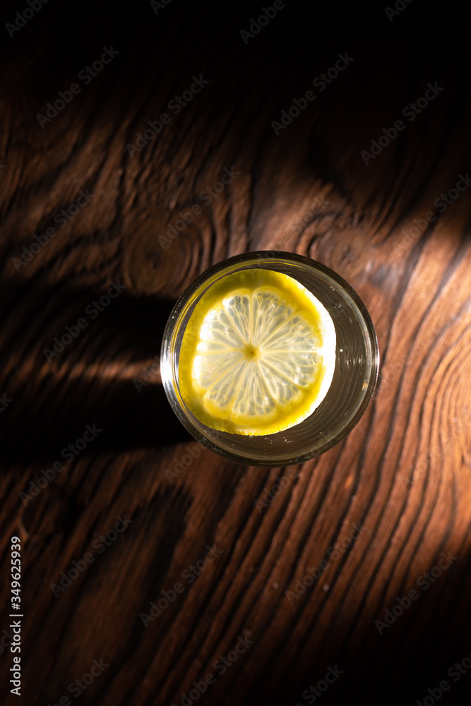 lemon in glass of water on black background