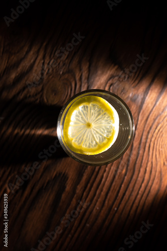 Obraz na płótnie lemon in glass of water on black background w salonie