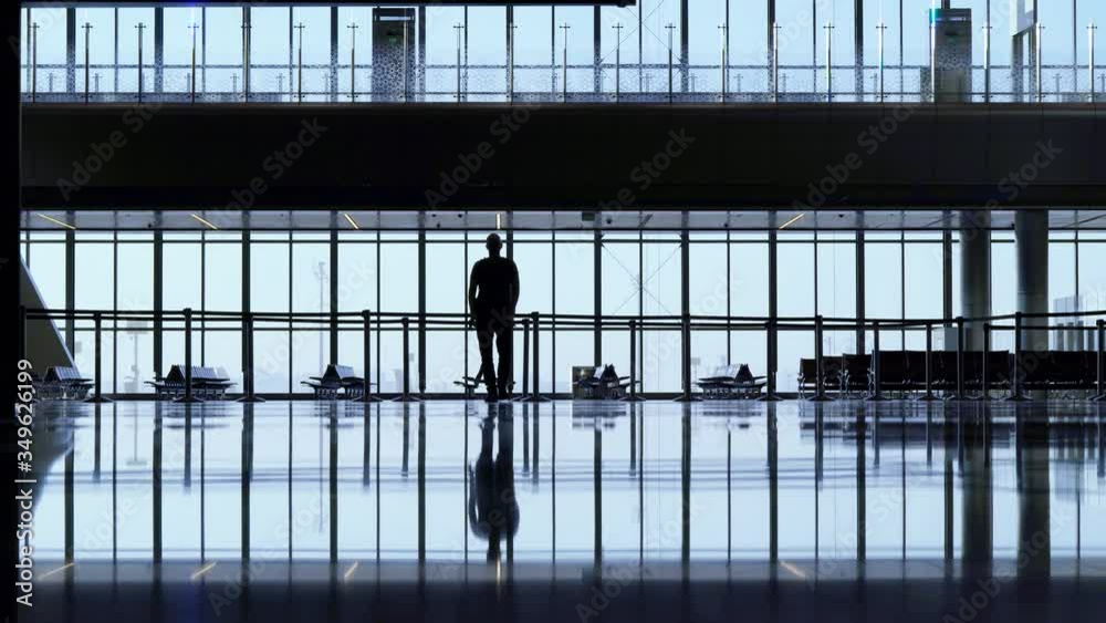 A male tourist in the big lobby of the airport. Empty waiting room, Airlines in crisis. A male tourist in the big lobby of the airport. Empty waiting room, Airlines in crisis.